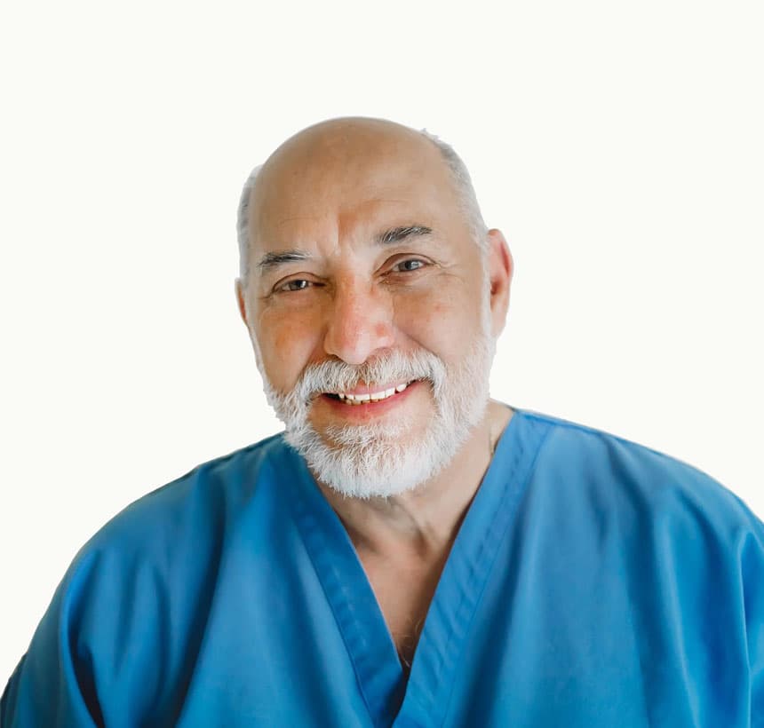 Il Dr. Paolo Carlo Biondo sorridente, con la divisa da dentista azzurra
